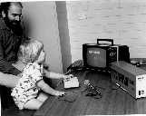 Dr Harvey Cohen supervises two-year old

 Alexander Zeno Cohen operating +- keyboard

 1975 microcomputer. Monitor is adapted TV